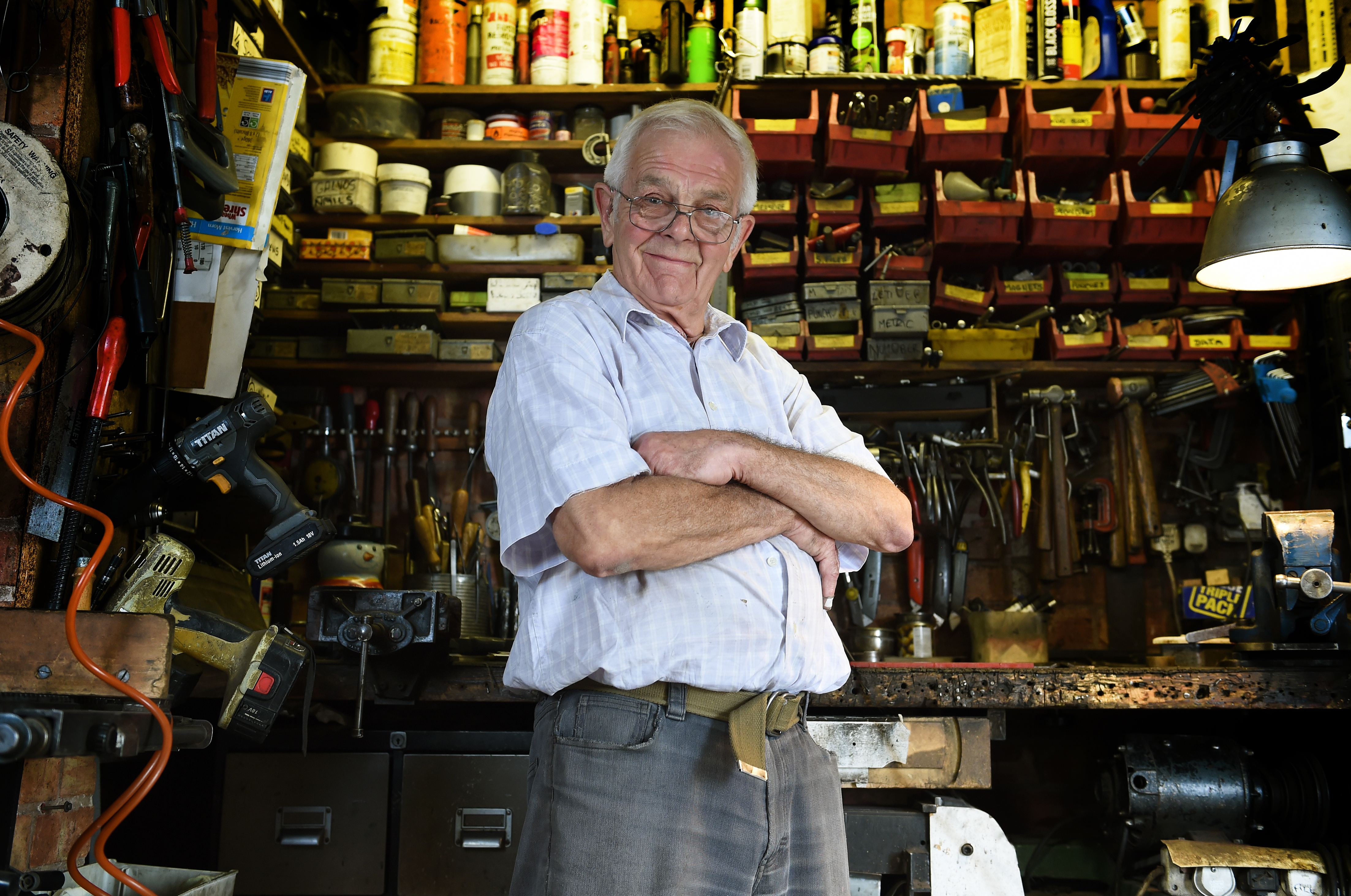 A man with his arms folded in a workshop