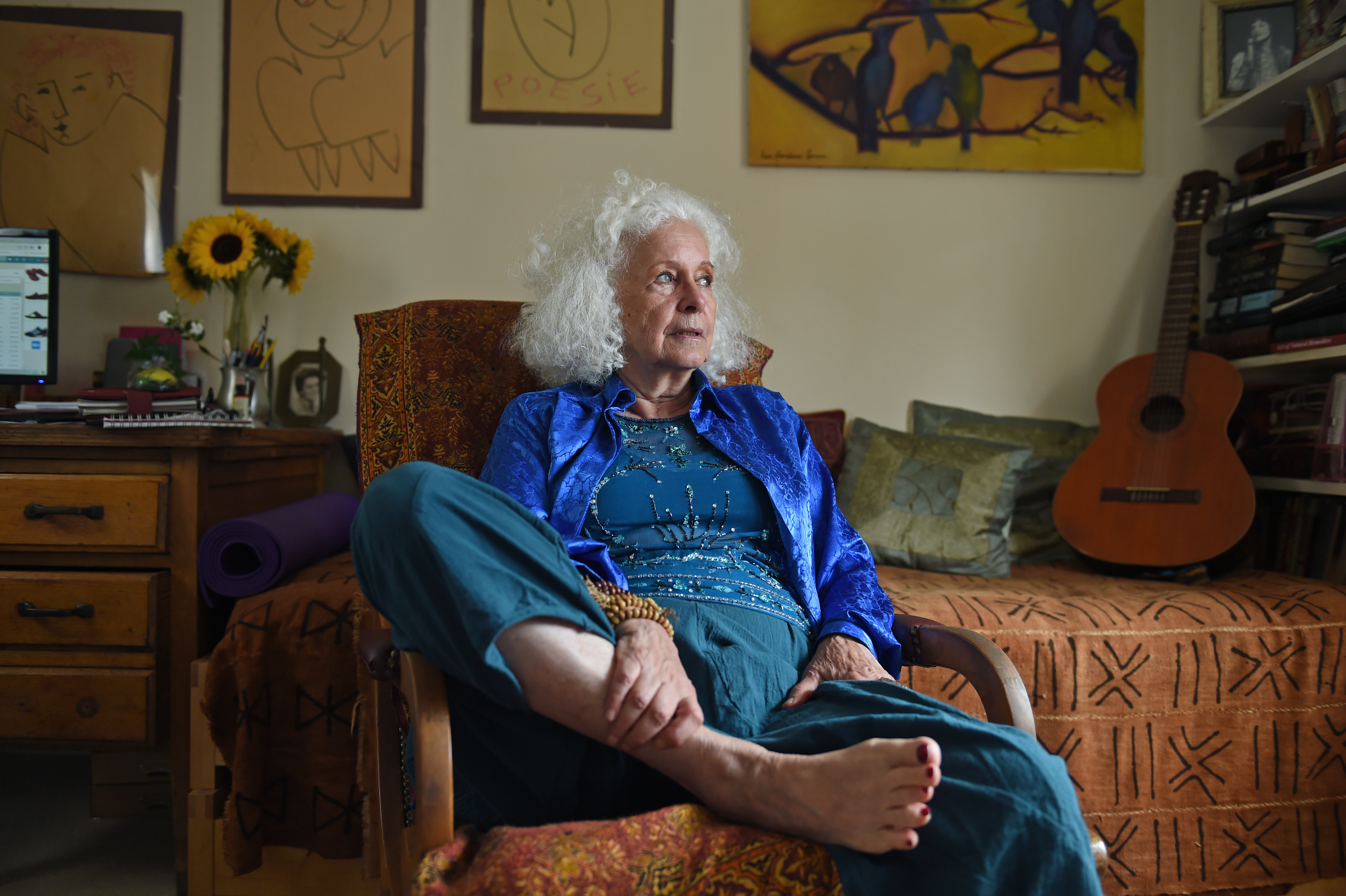 A woman sat in her flat looking out of the window