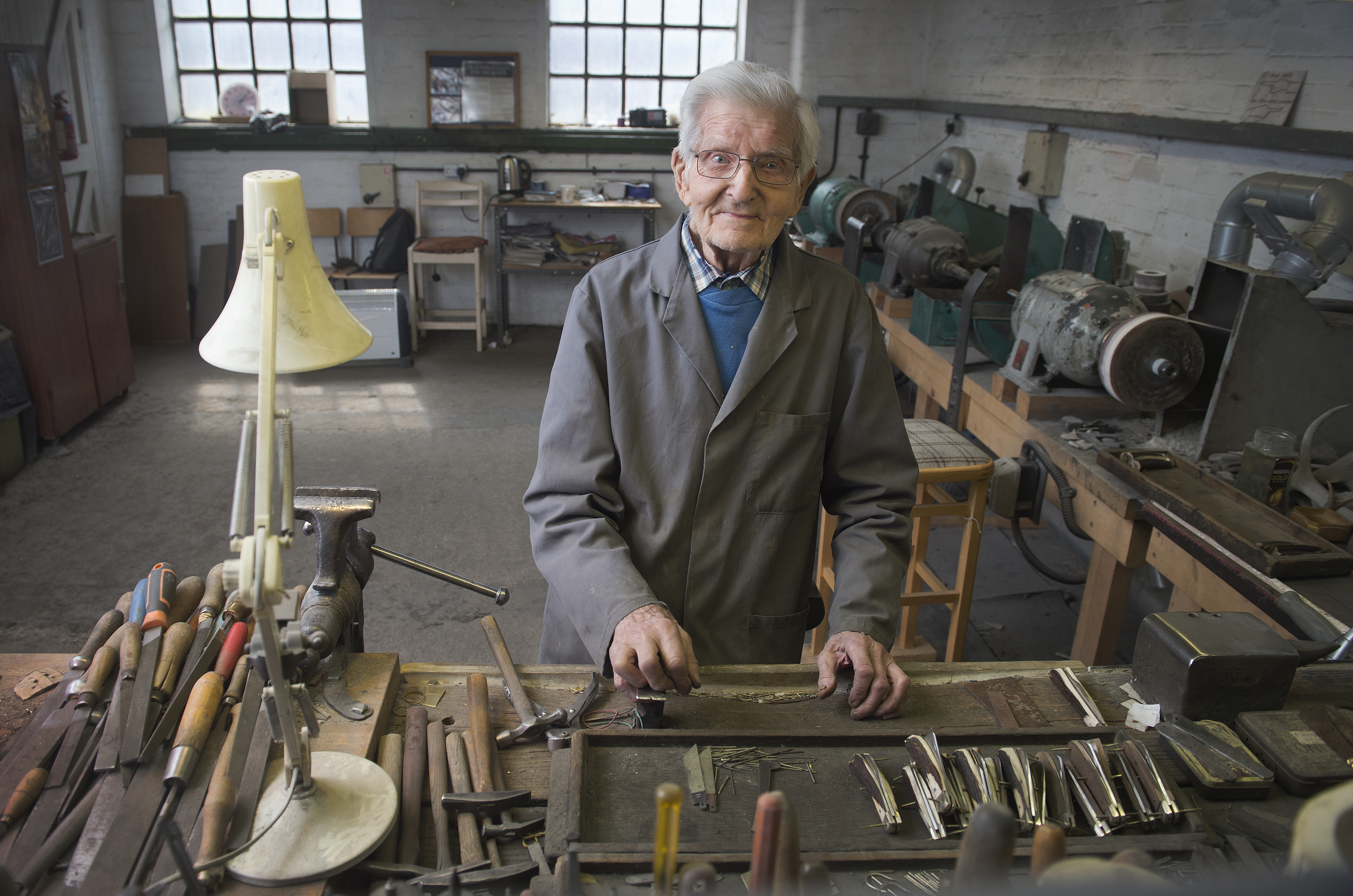 A man in a workshop with traditional tools