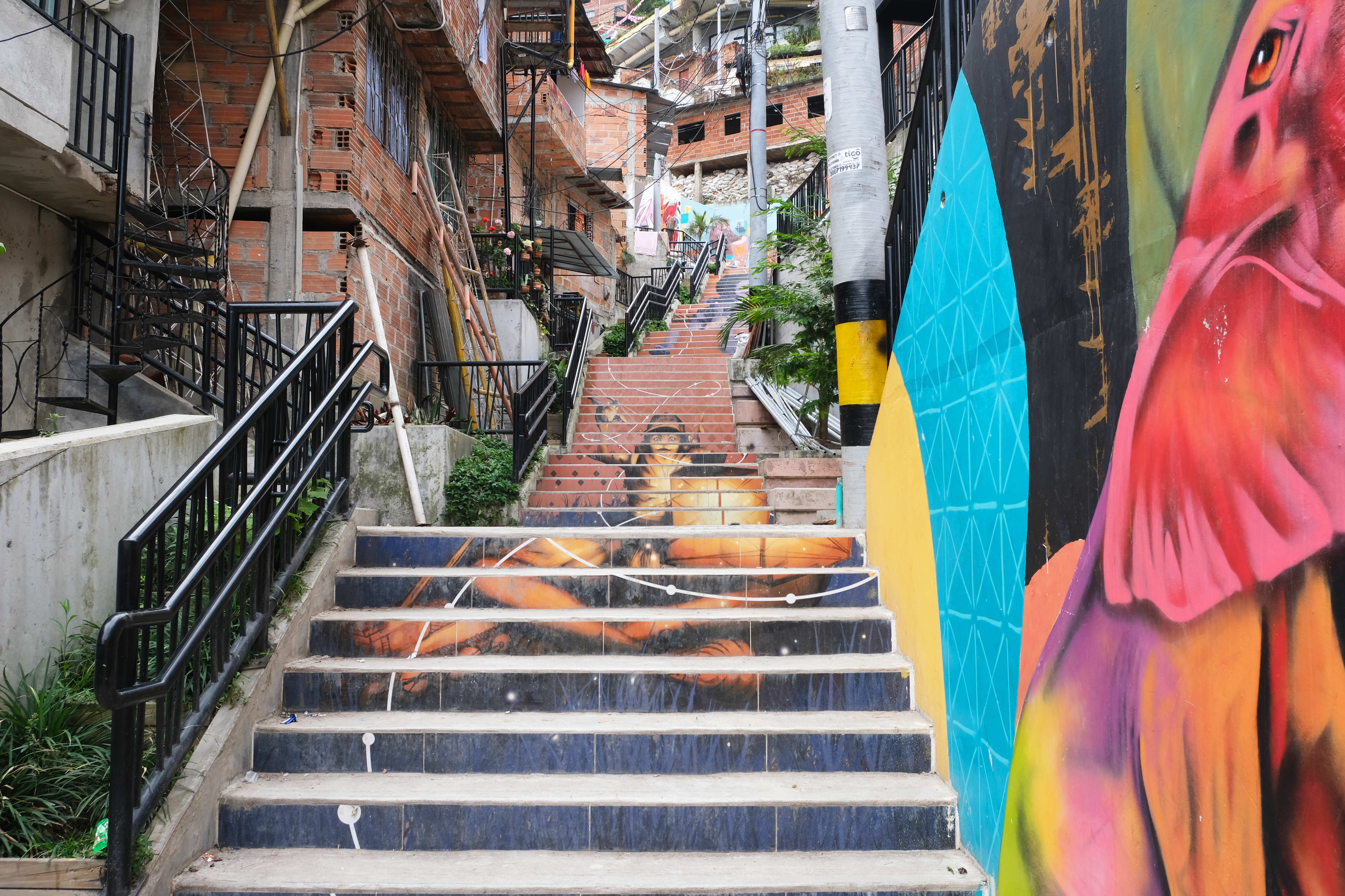 colourful stairway tiled and leading up through basic brick building on a hillside